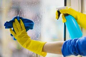 Gloved Hand Cleaning Window Rag And Spray